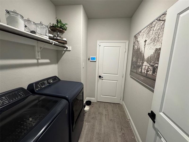 Laundry area featuring light wood-style flooring and washing machine and clothes dryer Laundry area featuring light wood-style flooring and washing machine and clothes dryer