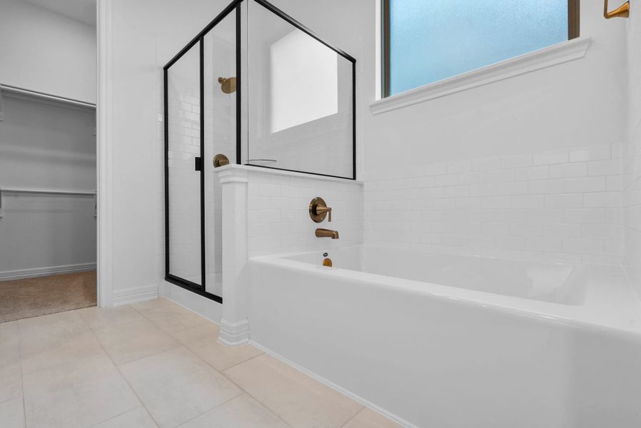 A spa-like retreat featuring a walk-in shower and a deep soaking tub.