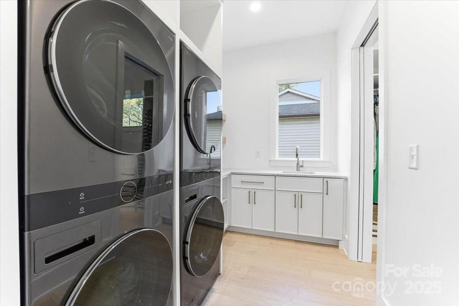 Laundry room with quartzite stone countertops, a full sink, storage areas, and room for double washer and dryer hookups. Laundry room with quartzite stone countertops, a full sink, storage areas, and room for double washer and dryer hookups.