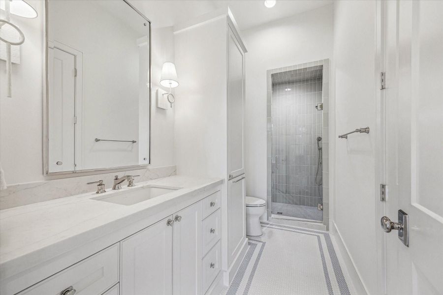 Downstairs Guest Suite Bath with custom designer tiles, counters, mirror, and lighting! Nice size shower and storage! Oversized closet. Downstairs Guest Suite Bath with custom designer tiles, counters, mirror, and lighting! Nice size shower and storage! Oversized closet.
