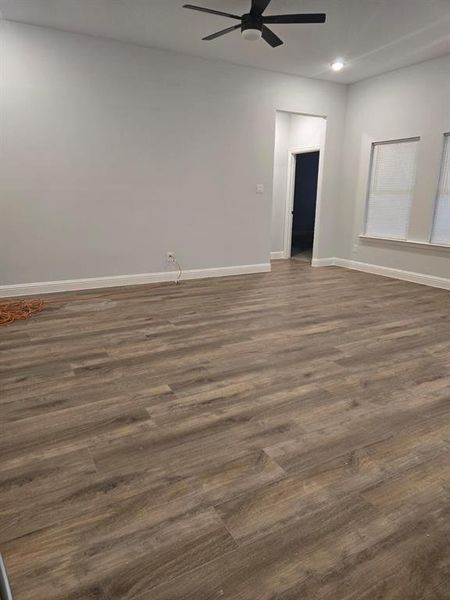 Unfurnished room featuring ceiling fan and dark wood-type flooring