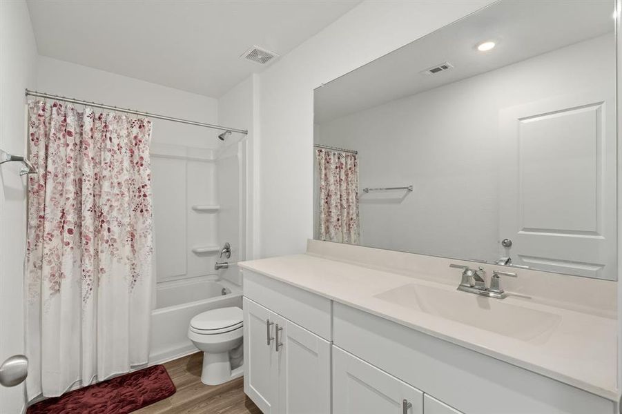 Step into the stunning secondary bathroom, where a lavish shower/tub combo, oversized mirror, extended countertop and sleek finishes await.