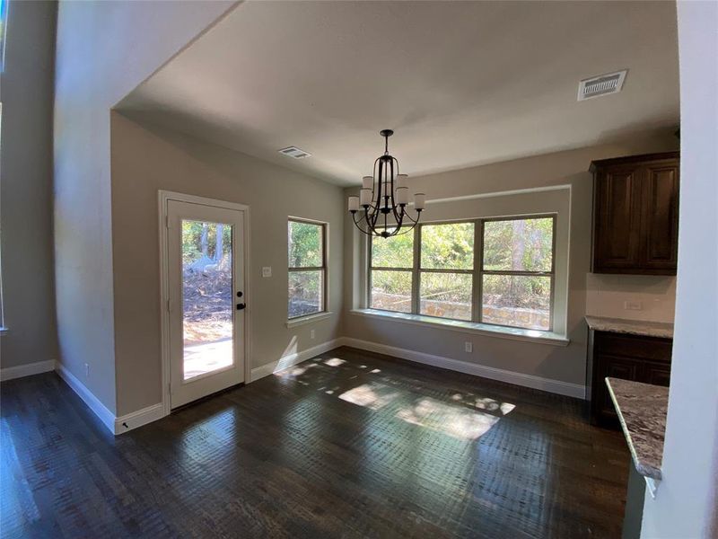 Breakfast area with built-in window seat and a view out to the tree line.