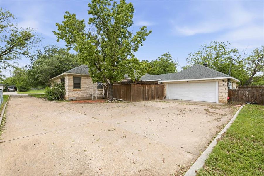Spacious concrete driveway featuring ample parking and direct access to a two-car garage Spacious concrete driveway featuring ample parking and direct access to a two-car garage