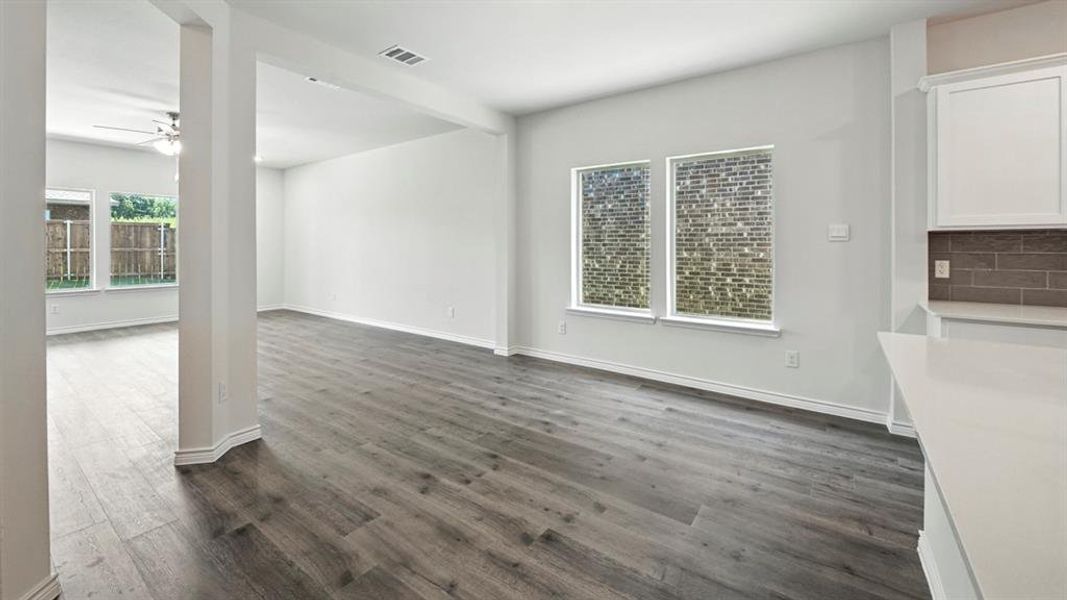 Unfurnished dining area featuring dark wood finished floors and ceiling fan Unfurnished dining area featuring dark wood finished floors and ceiling fan