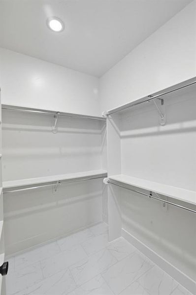 Walk in closet featuring light marble finish floors Walk in closet featuring light marble finish floors