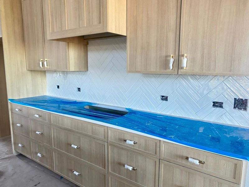 Kitchen with light brown cabinetry, tasteful backsplash, and modern cabinets