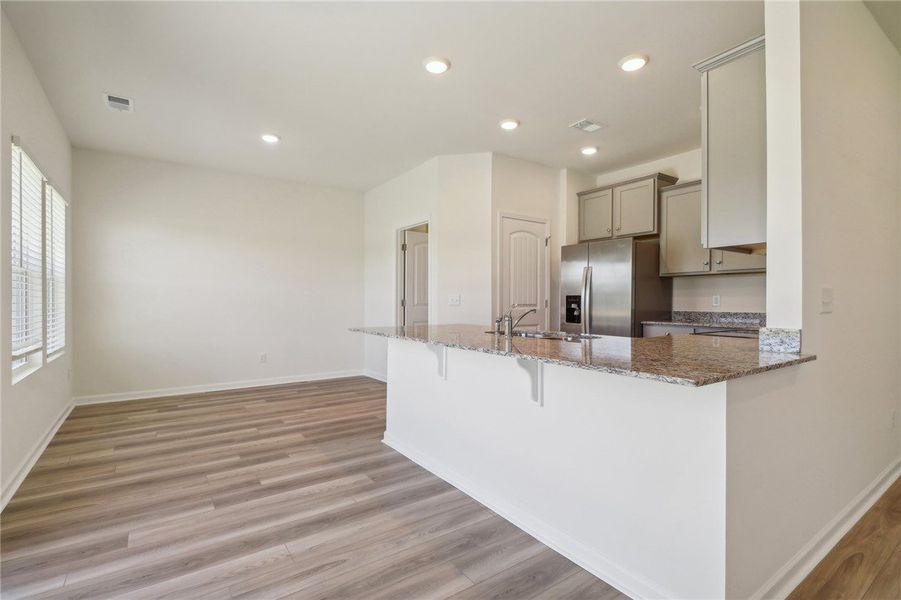 This bright kitchen and living area features a bre This bright kitchen and living area features a bre