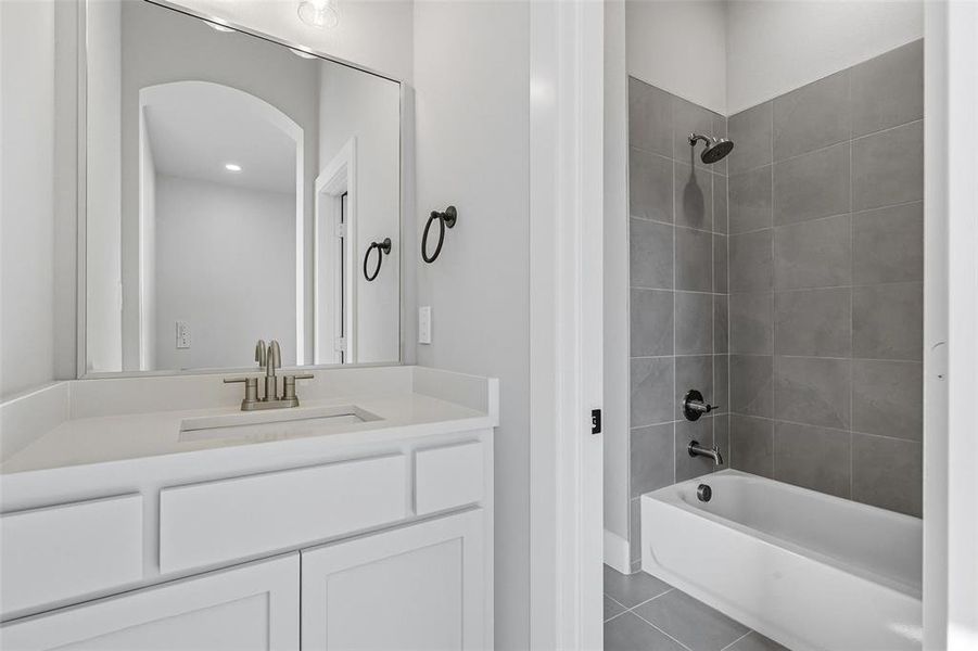 Bathroom with shower / washtub combination, vanity, and dark tile patterned flooring Bathroom with shower / washtub combination, vanity, and dark tile patterned flooring