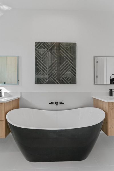 A stylish freestanding tub anchors this serene bathroom with dual floating vanities and modern fixtures. A stylish freestanding tub anchors this serene bathroom with dual floating vanities and modern fixtures.