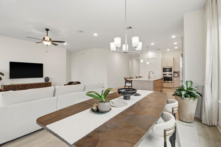 Elegant open-concept living space with a modern kitchen, cozy seating area, and stylish dining setup, all enhanced by natural light and contemporary finishes.