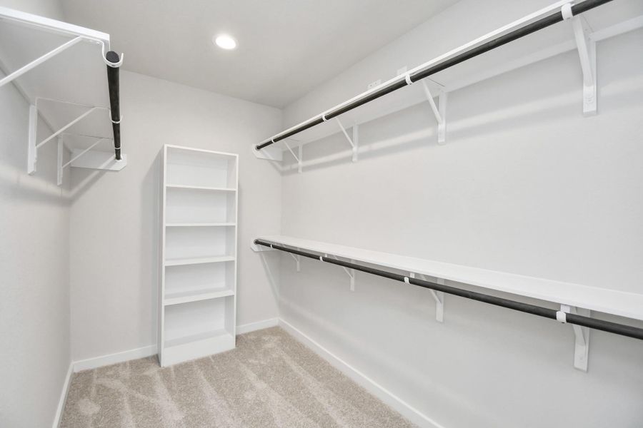 Walk-in closet that epitomizes luxury and practicality. This generously sized space features built-in shelving, offering abundant room for impeccable organization. High ceilings and recessed lighting create a bright and welcoming ambiance. Sample photo of completed home with similar floor plan. Actual colors and selections may vary. Walk-in closet that epitomizes luxury and practicality. This generously sized space features built-in shelving, offering abundant room for impeccable organization. High ceilings and recessed lighting create a bright and welcoming ambiance. Sample photo of completed home with similar floor plan. Actual colors and selections may vary.