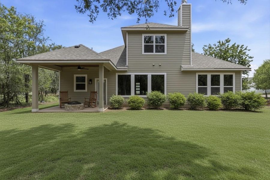 A spacious backyard with a covered patio and fire pit, perfect for outdoor relaxation and entertainment.