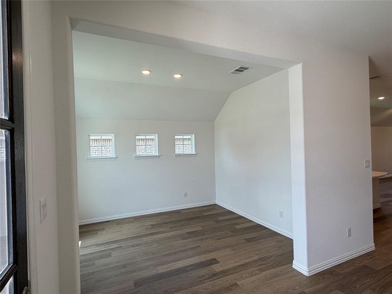 Spacious interior area featuring wood-finish flooring, recessed lighting, and three transom-style windows