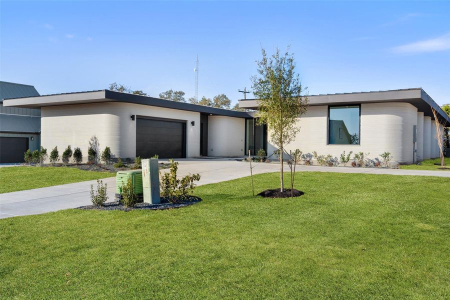 View of front of property with a front lawn and a garage