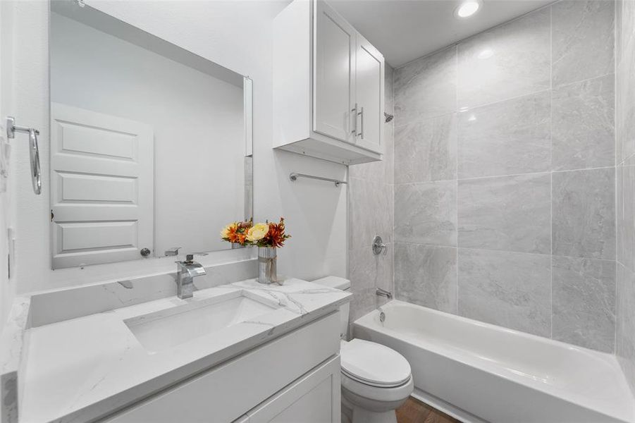 Bathroom featuring a full vanity with a rectangular undermount sink, a polished chrome faucet, and a large frameless mirror