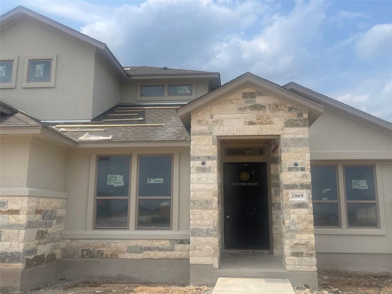 Front exterior of a new home in Leander Estates, Leander, TX, highlighting curb appeal (Image 1).