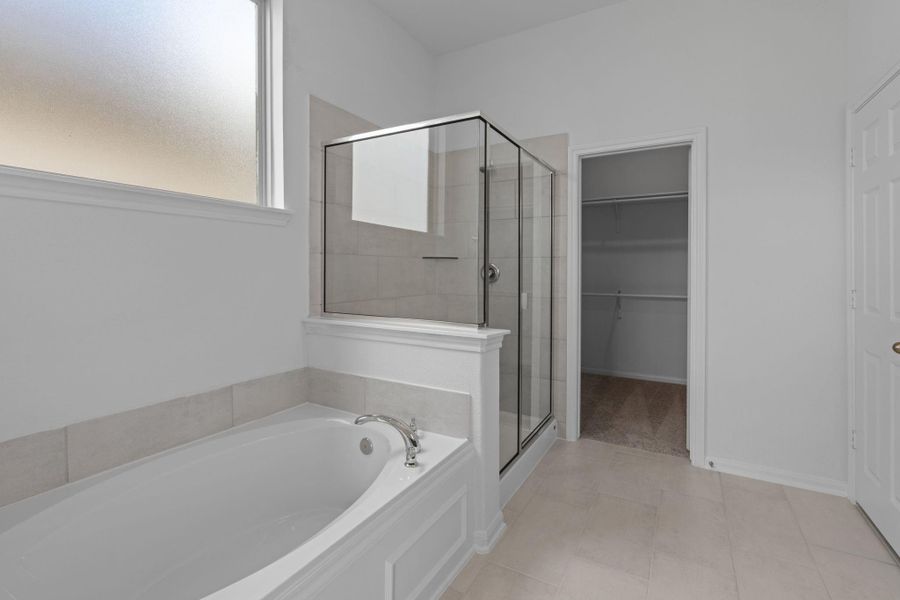 This additional view of your primary bathroom features tile flooring, fresh paint, walk-in shower, a separate garden tub, and a large walk-in closet. This additional view of your primary bathroom features tile flooring, fresh paint, walk-in shower, a separate garden tub, and a large walk-in closet.