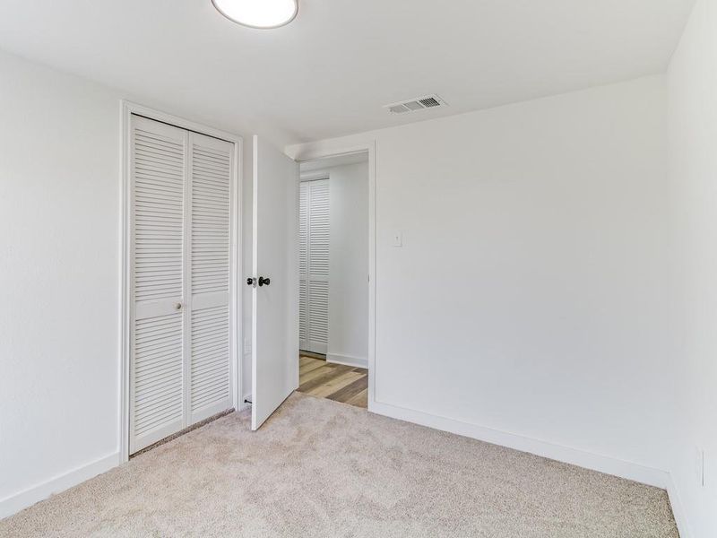 Unfurnished bedroom with carpet and a closet Unfurnished bedroom with carpet and a closet