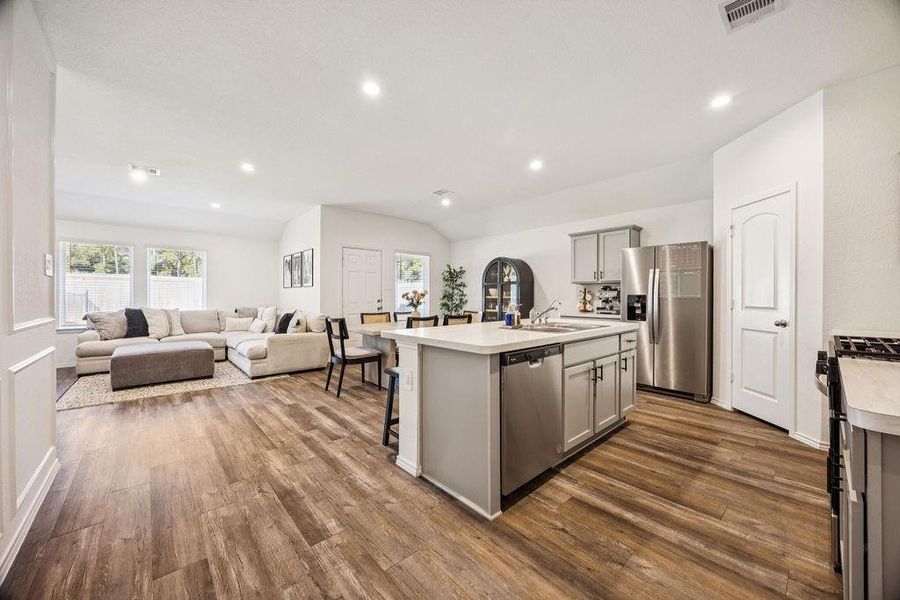 Spacious open-concept kitchen, dining, and living area with modern appliances and elegant wood flooring, perfect for entertaining. Spacious open-concept kitchen, dining, and living area with modern appliances and elegant wood flooring, perfect for entertaining.