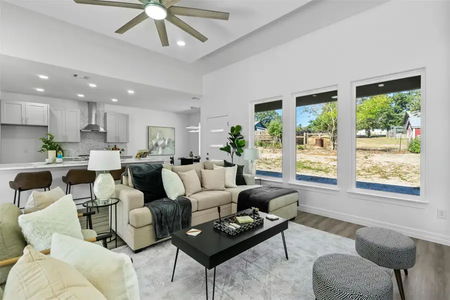 Living room featuring light wood-type flooring, recessed lighting, and a ceiling fan