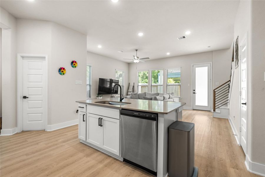 The oversized island anchors the main living area, creating a natural gathering place while maintaining clear sightlines to the living room and backyard beyond.