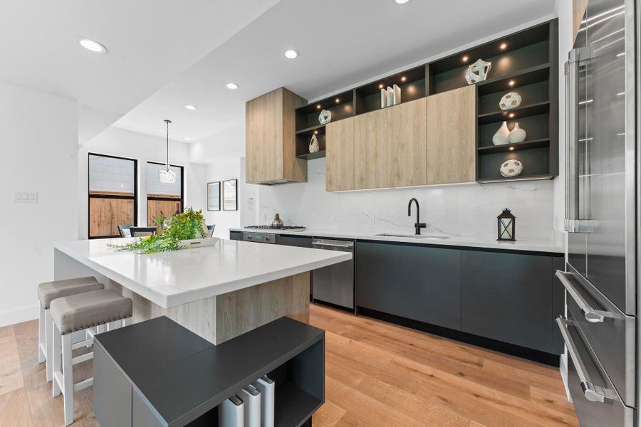 Dual workstations, custom open shelving, and seamless quartz backsplashes define a space that’s as intuitive as it is stunning. Dual workstations, custom open shelving, and seamless quartz backsplashes define a space that’s as intuitive as it is stunning.