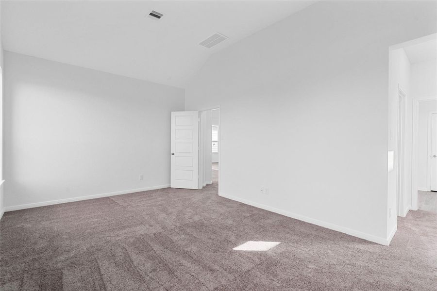 This view from the primary bedroom shows the seamless flow to the spacious walk-in closet and luxurious en-suite bathroom, creating a true suite experience.