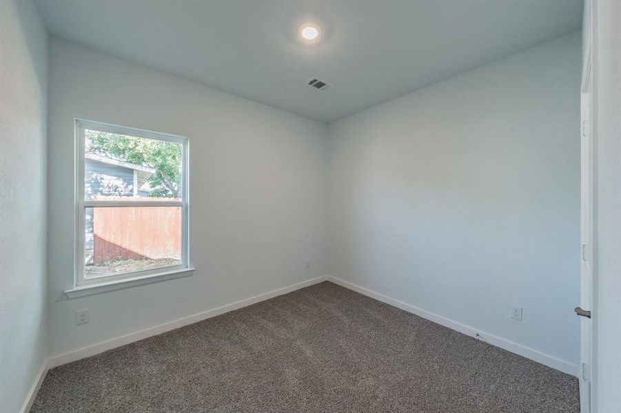 Unfurnished room featuring dark colored carpet and baseboards Unfurnished room featuring dark colored carpet and baseboards