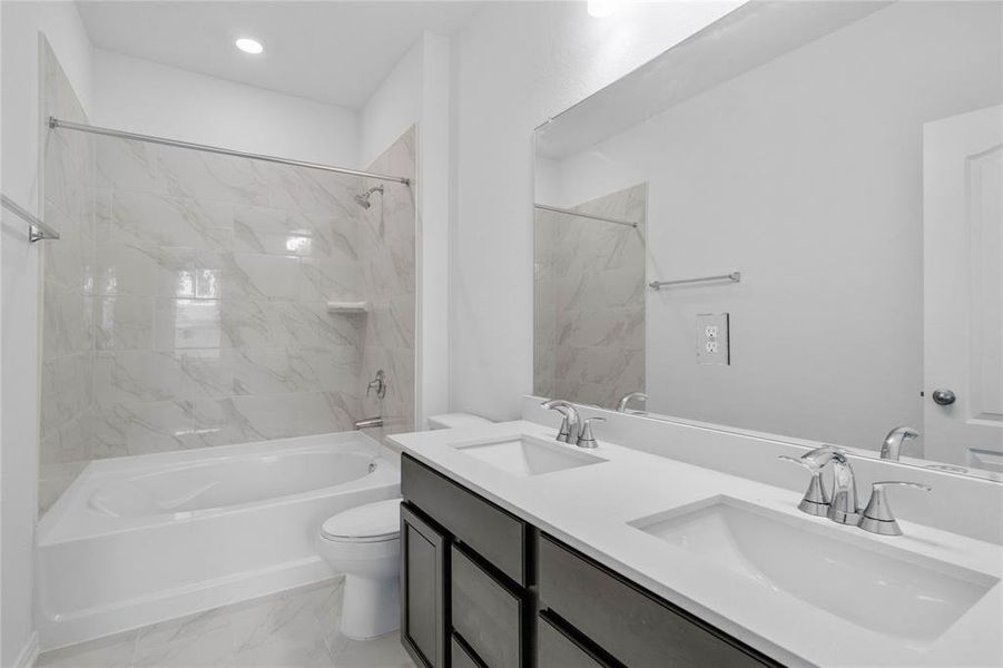 This primary bathroom is definitely move-in ready! Featuring an oversized tub and shower combo with tile surround, stained cabinets with light countertops, dual vanities, high ceilings, neutral paint, sleek and modern finishes.