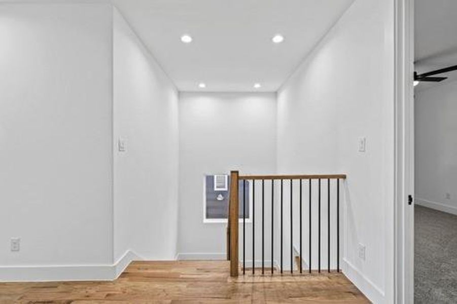 Hallway with hardwood / wood-style floors