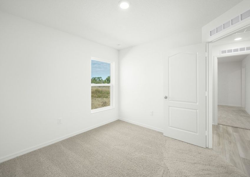 The secondary bedroom includes plush carpeting and a ceiling fan!