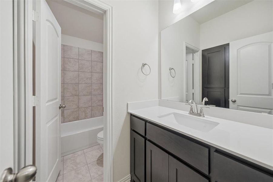 Full bath featuring vanity, shower / washtub combination, and light tile patterned floors
