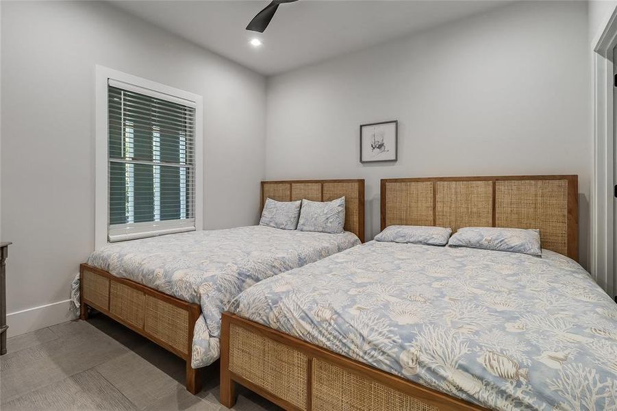 A well-lit bedroom provides ample rest with two comfortable beds and clean lines.