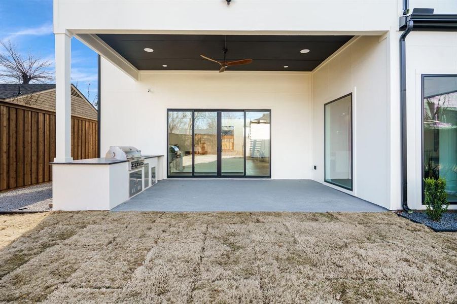 Back of house with an outdoor kitchen, ceiling fan, and a patio