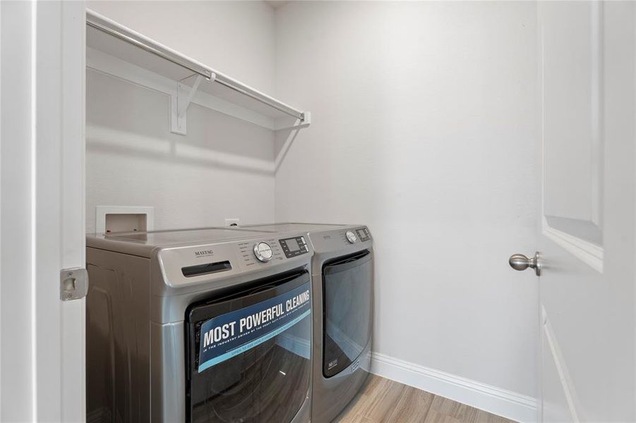 Laundry area with washer and dryer and light wood-style flooring