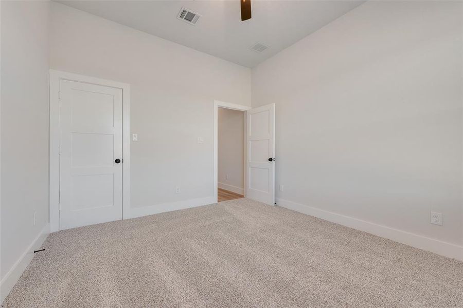 Spacious room featuring neutral carpet flooring, light-toned walls, and white trim