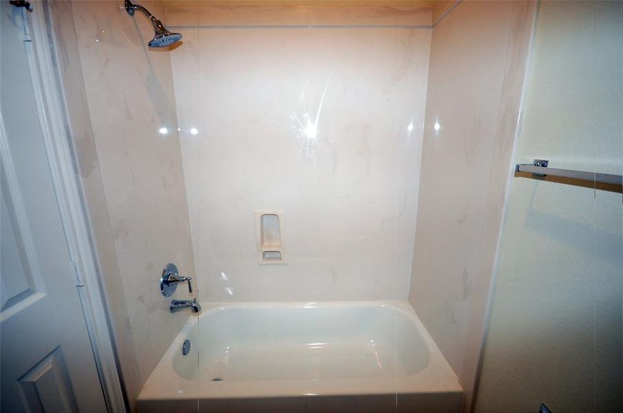 Tub with cultured marble walls in the garage bath.