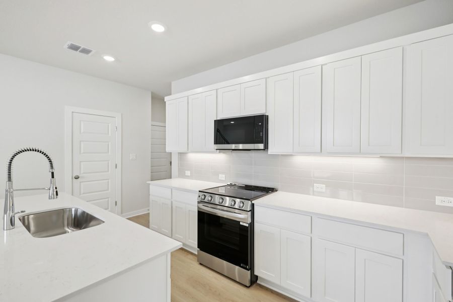 A kitchen with white cabinets.