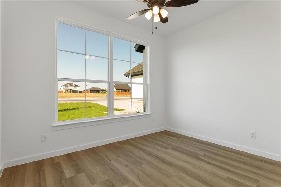 Empty room with wood-type flooring and ceiling fan