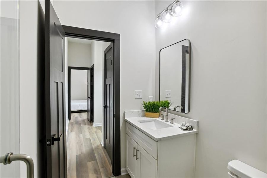 Bathroom featuring toilet, oversized vanity, and Luxury Vinyl Plank flooring