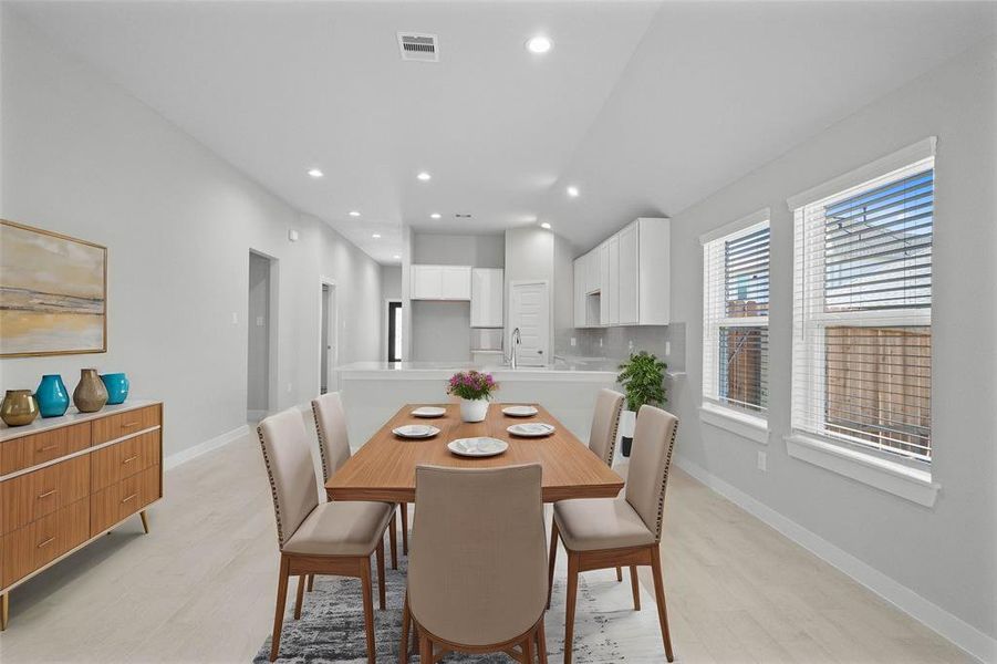 This lovely dining room is perfect for starting the day out on the right foot! This space showcases custom paint, high ceilings, recessed lighting, large windows adding to the ample natural light, and tile flooring!