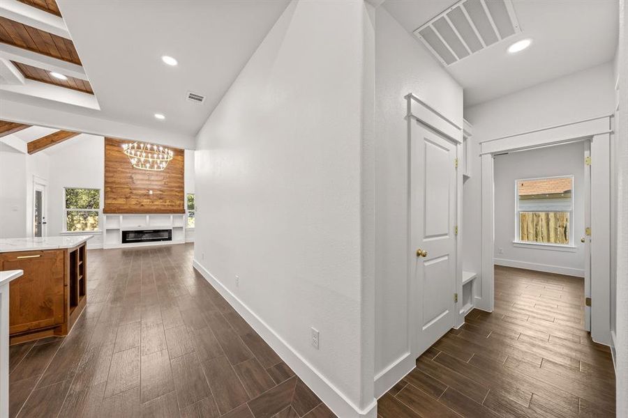 Hallway featuring dark wood-type flooring, a chandelier, and recessed lighting Hallway featuring dark wood-type flooring, a chandelier, and recessed lighting