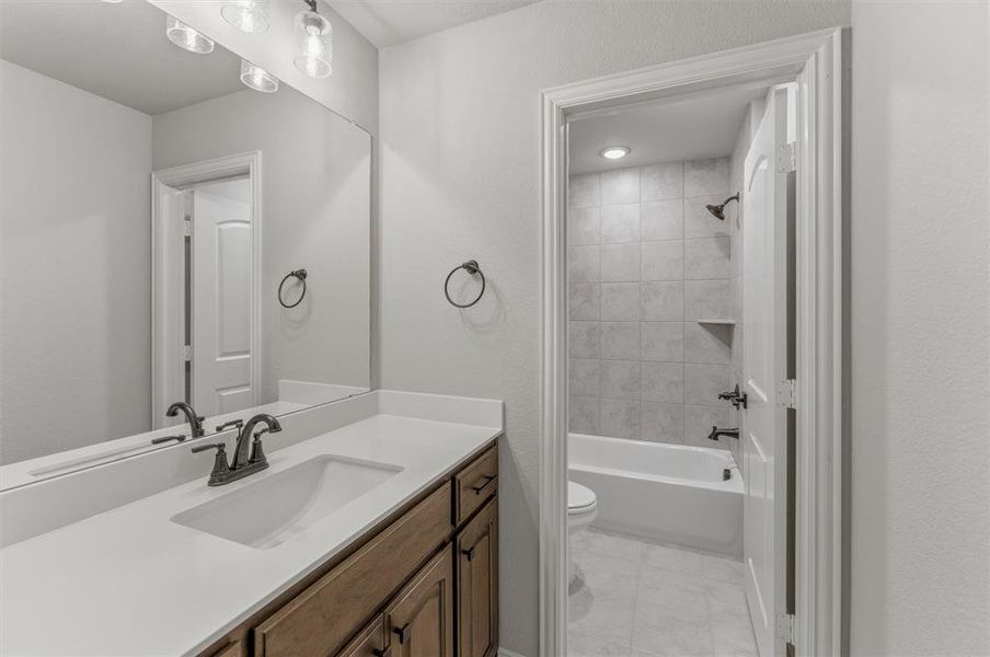 Bathroom vanity featuring a single undermount sink and a light-toned countertop