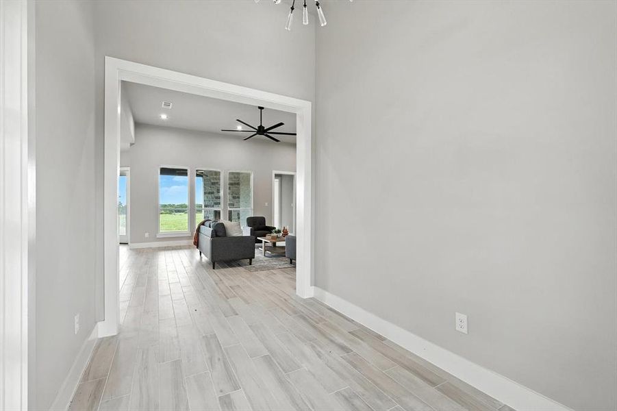 Hallway featuring light wood-style floors and a chandelier Hallway featuring light wood-style floors and a chandelier