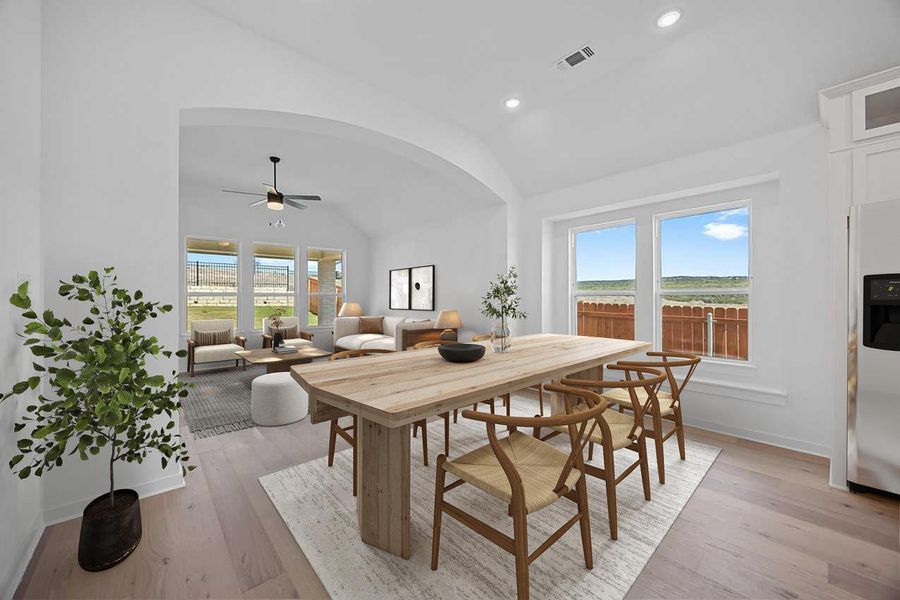Dining room with lofted ceiling, a ceiling fan, recessed lighting, light wood-style flooring, and arched walkways