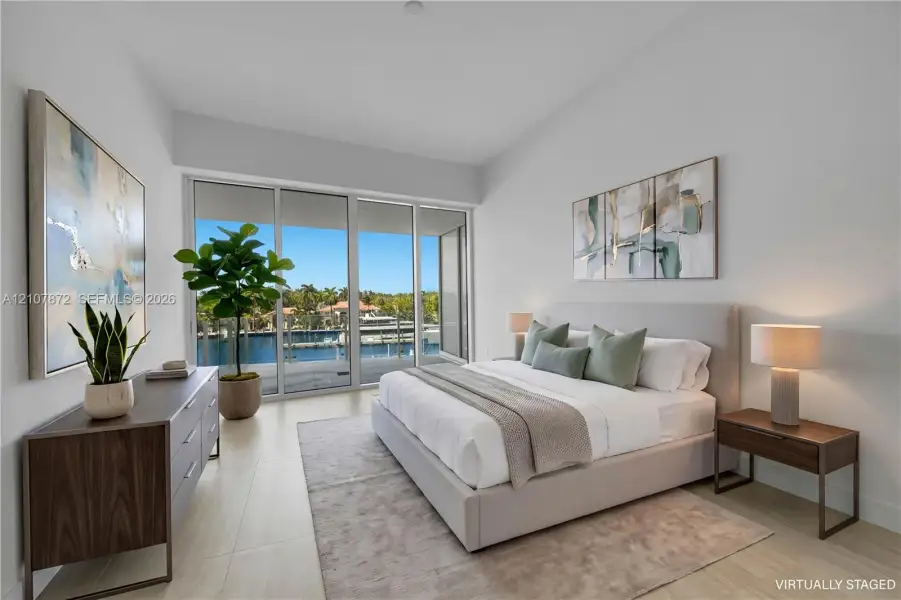 Floor-to-ceiling sliding glass doors, neutral tile flooring, and direct access to an outdoor balcony featuring a waterfront and marina setting Floor-to-ceiling sliding glass doors, neutral tile flooring, and direct access to an outdoor balcony featuring a waterfront and marina setting