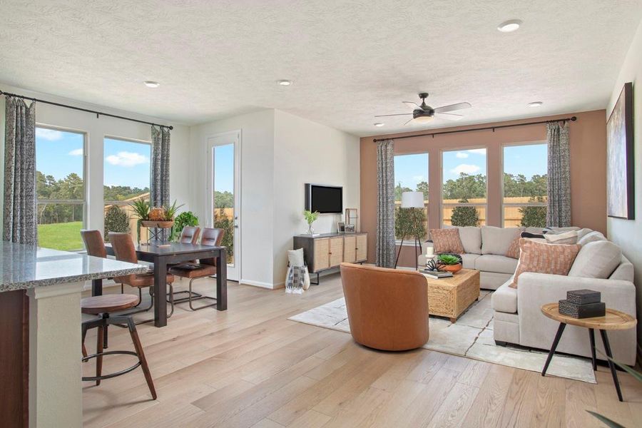 Flooded with natural light from large windows and a patio door, the Great Room feels bright and airy. Recessed lighting adds to the welcoming atmosphere, perfect for gathering with family and guests.