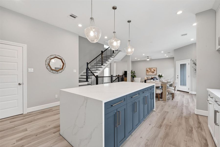 Kitchen island features ample storage space and pendant lighting Kitchen island features ample storage space and pendant lighting