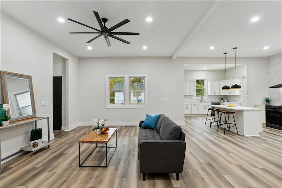 Living room featuring ceiling fan and light Luxury Vinyl Plank flooring